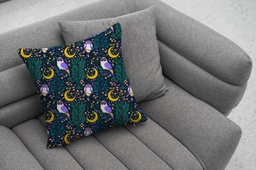 celestial night owl patten on teal throw pillow placed on grey couch