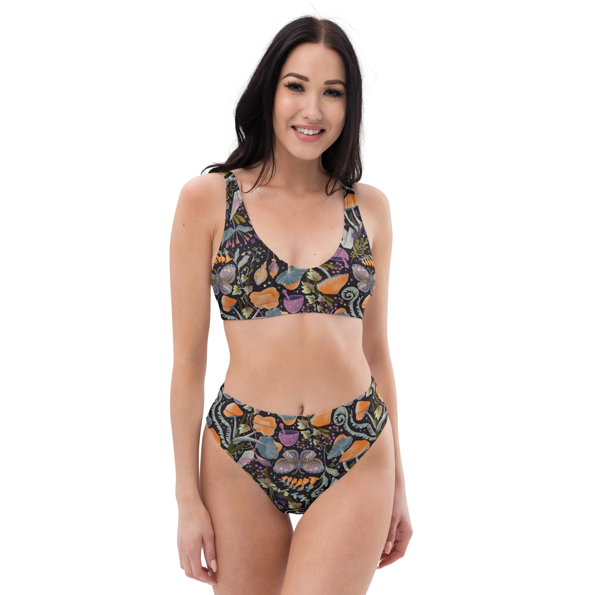 A model wearing a high-waisted bikini set made from recycled materials with a whimsical mushroom design. The top has a scoop sport bra style, and the bottom has a flattering high-waist cut.