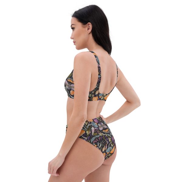 A model wearing a high-waisted bikini set made from recycled materials with a whimsical mushroom design. The top has a scoop sport bra style, and the bottom has a flattering high-waist cut.